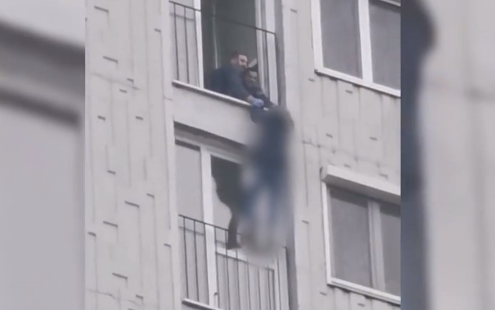 Rendőrök mentették meg a nőt, aki 50 méteres magasságban lógott egy panelház ablakában - Videó